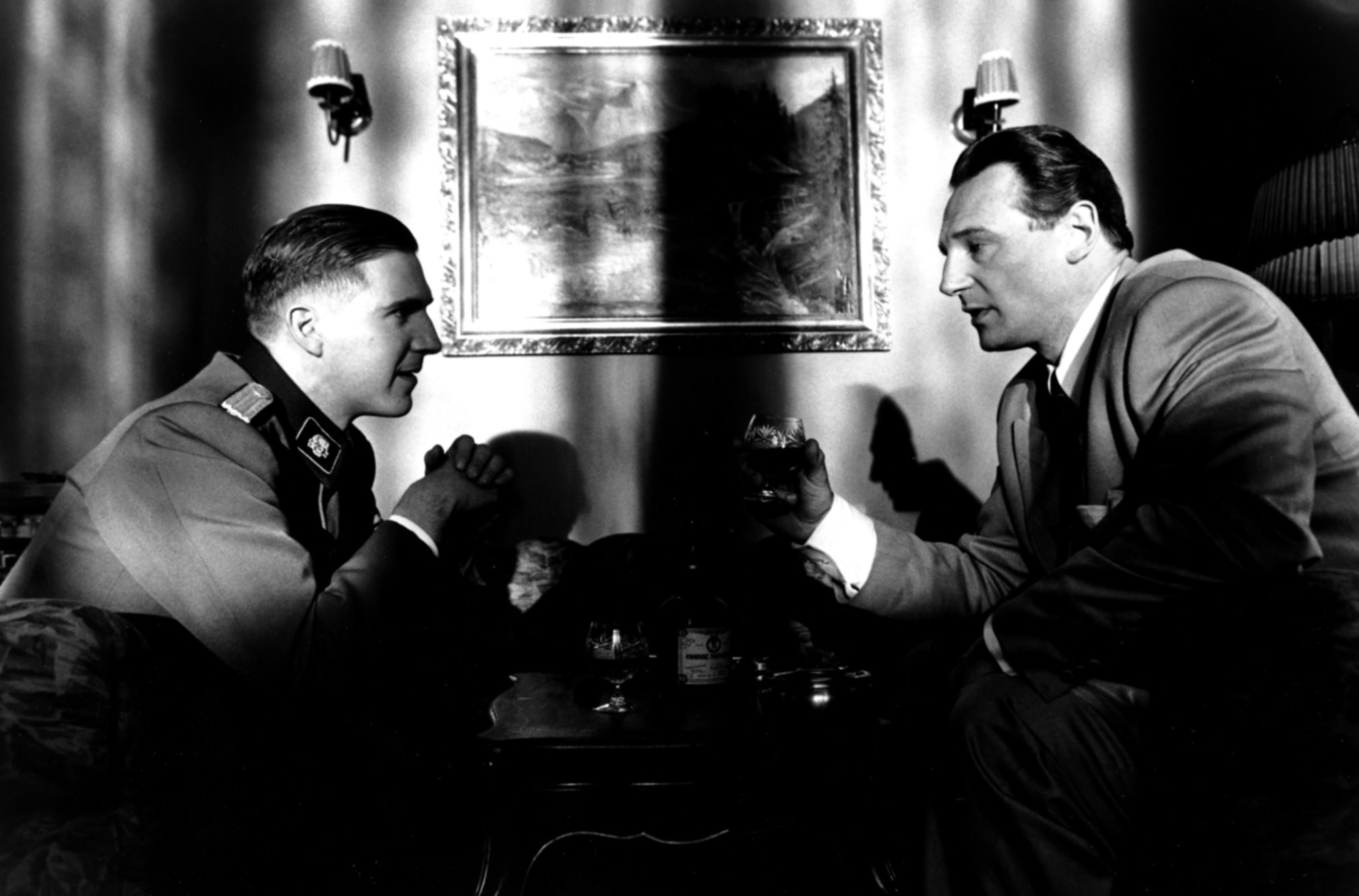 Amon Goeth and Schindler talk in a dark office