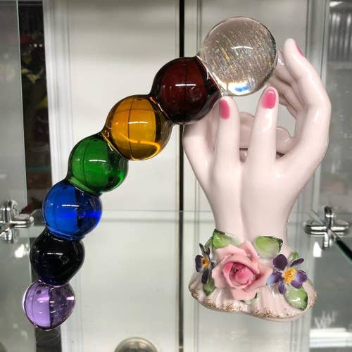 Multicolore beaded glass dildo posed with mannequin hands