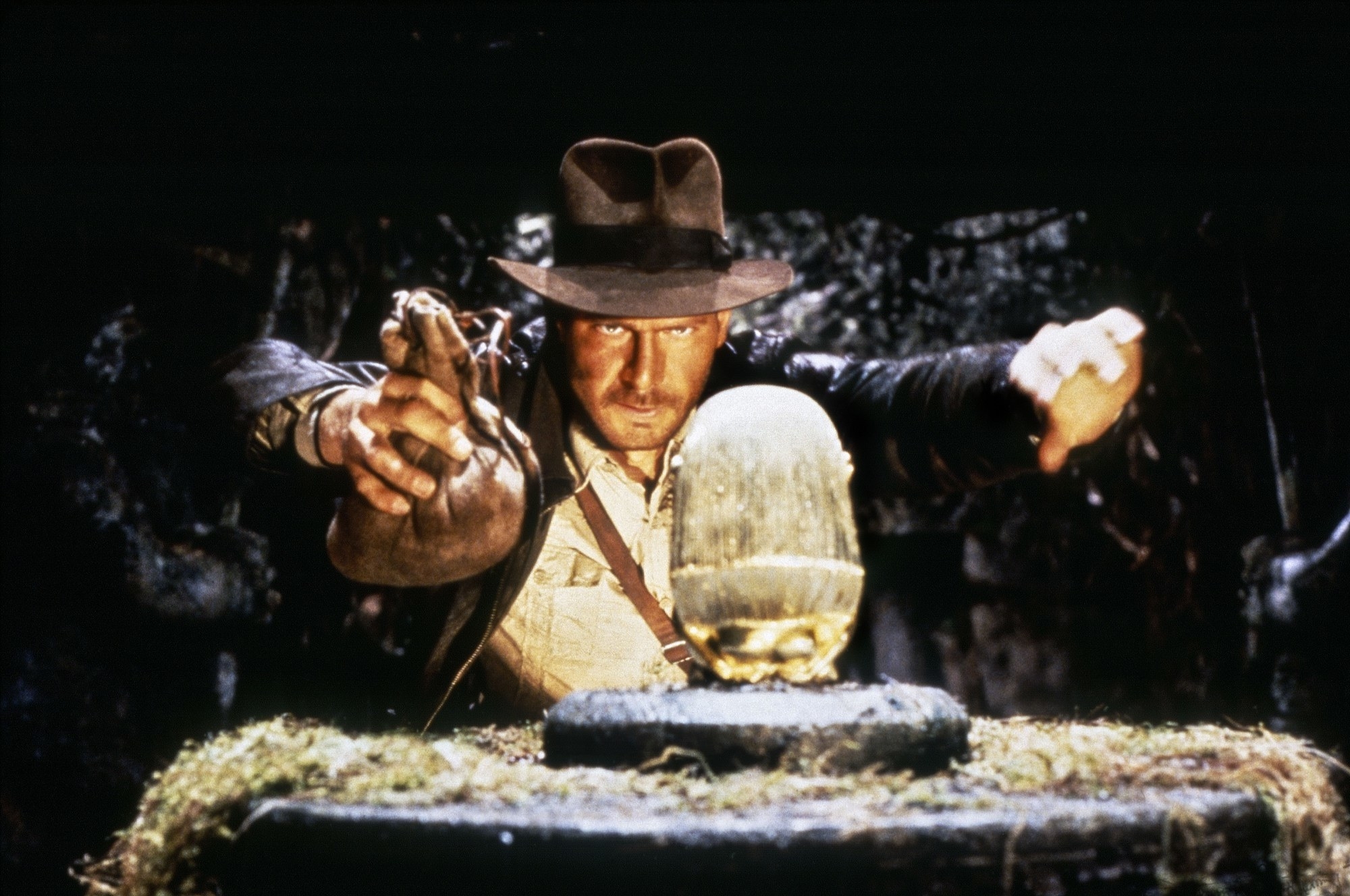 Indiana Jones holding a bag of sand ready to swap it out for an ancient gold idol
