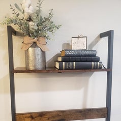 A reviewer shares the top shelf of their ladder, decorated with a plants and stacked books