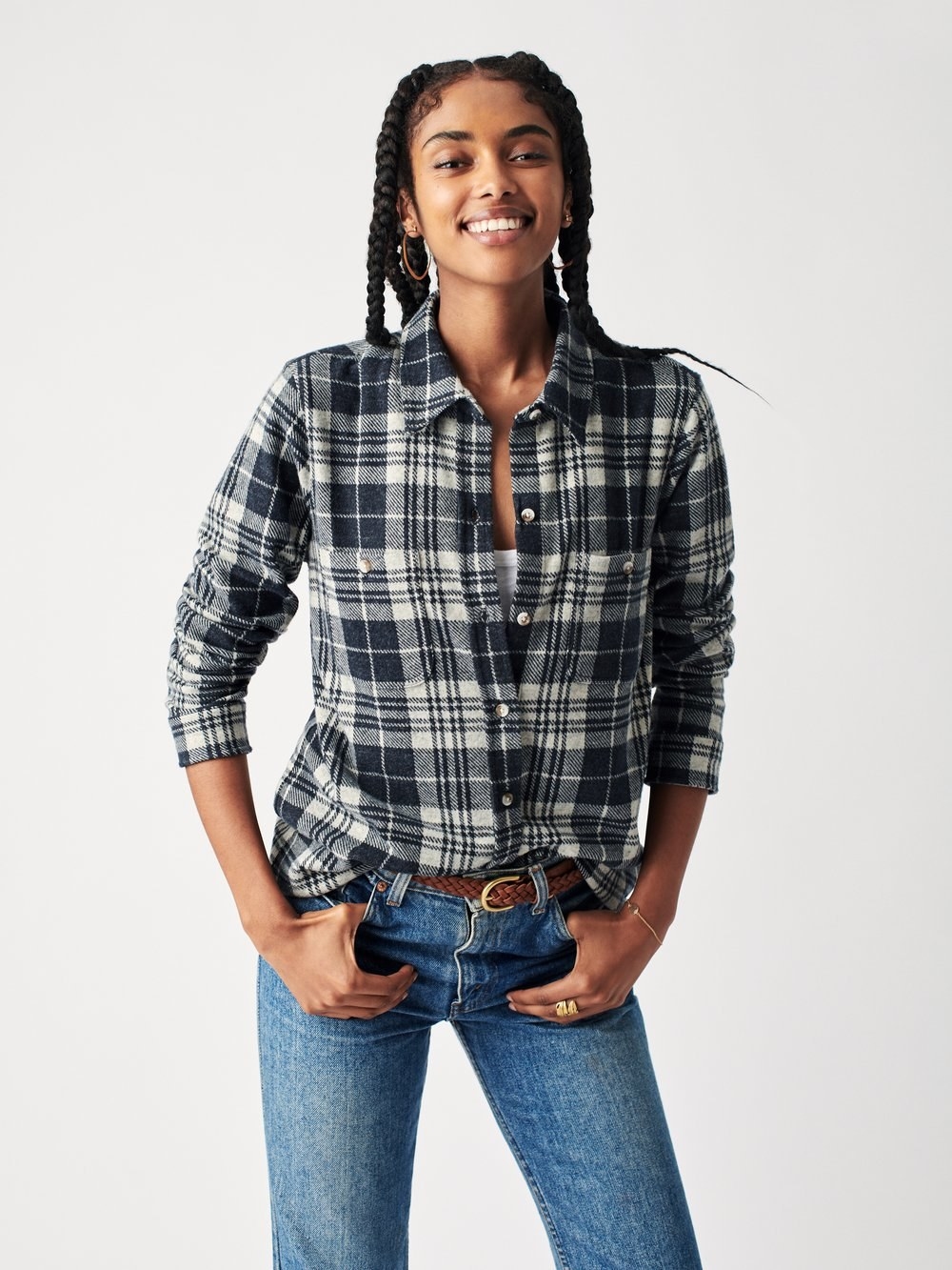 model wearing a blue and cream flannel tucked into blue jeans