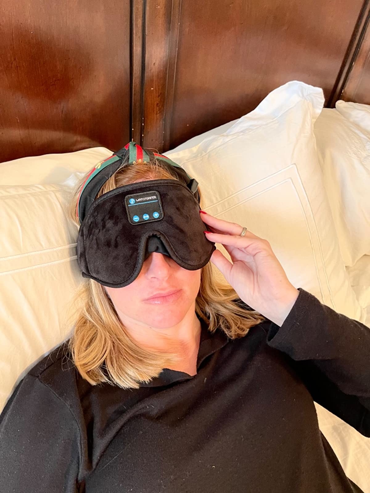 Reviewer wearing the headphone eye mask in bed