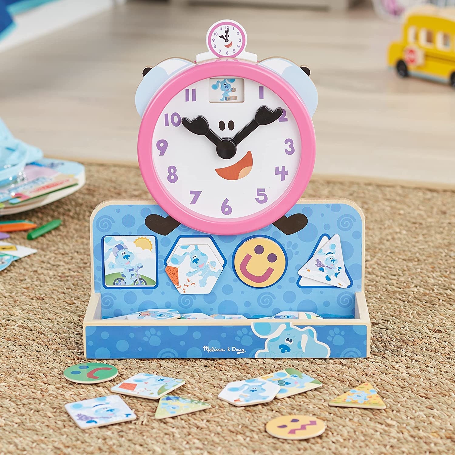 The pink wooden clock with a blue storage base and wooden magnets