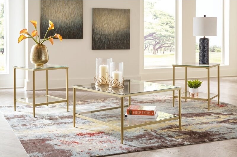 a glass coffee table and two ends tables