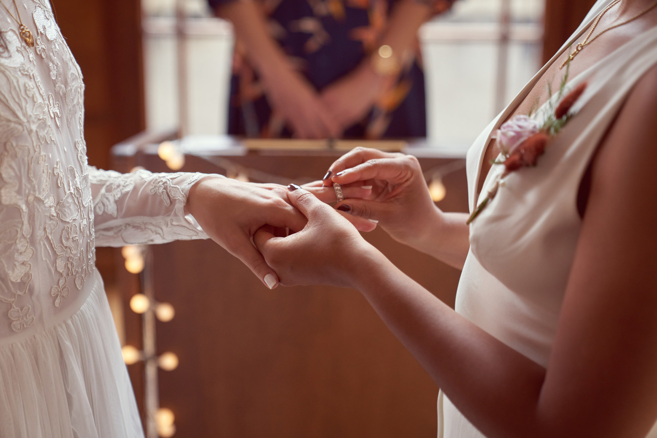 A person placing a ring on their betrothed&#x27;s finger at the alter