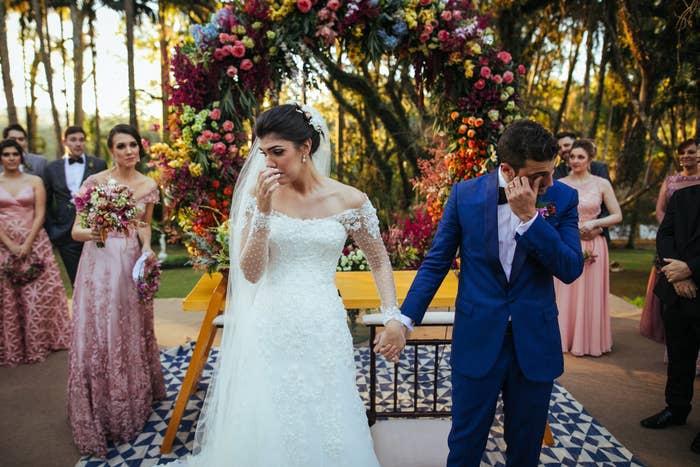 A bride and groom holding hands before walking down the aisle