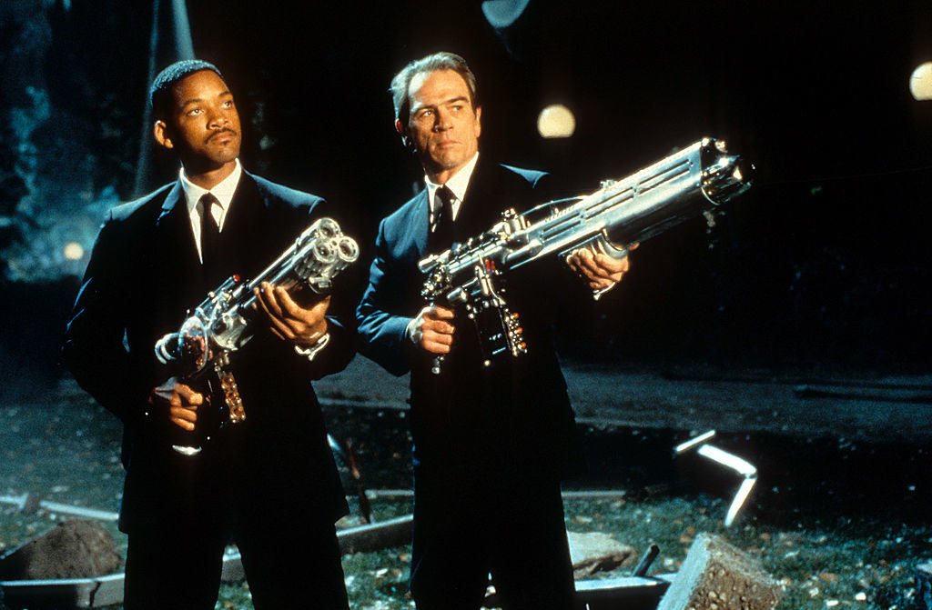 Will and Tommy Lee Jones holding weapons in a scene from Men In Black