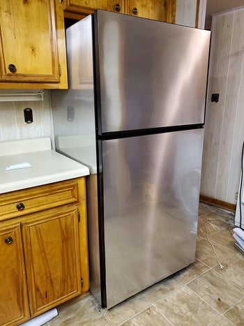 on factual, same fridge with metal silver vinyl peel and stick wallpaper covering primitive flooring