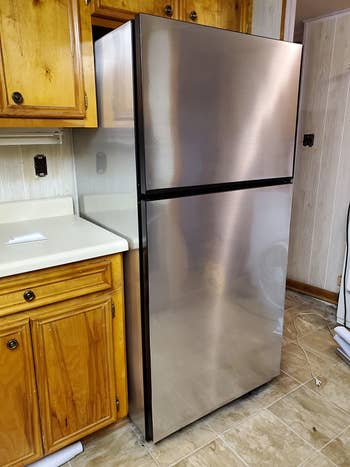 on right, same fridge with metallic silver vinyl peel and stick wallpaper covering old surface