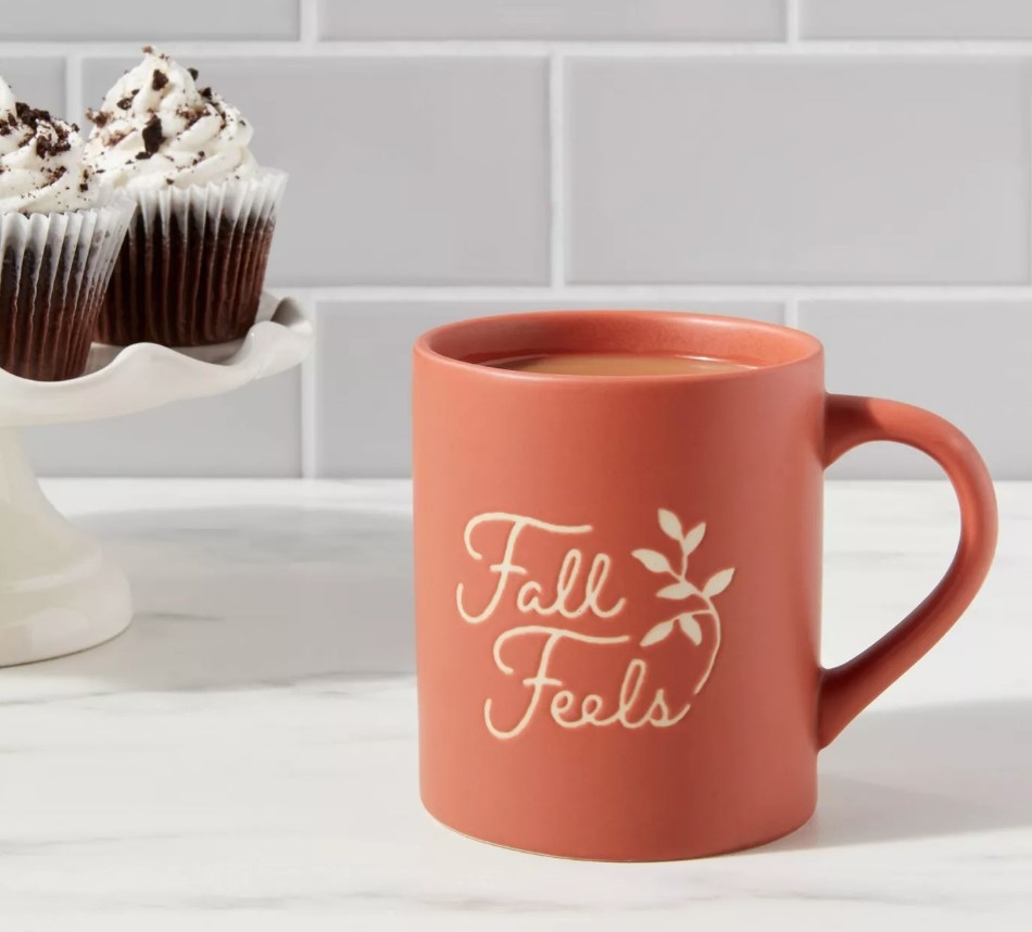 An orange mug that reads "fall feels"