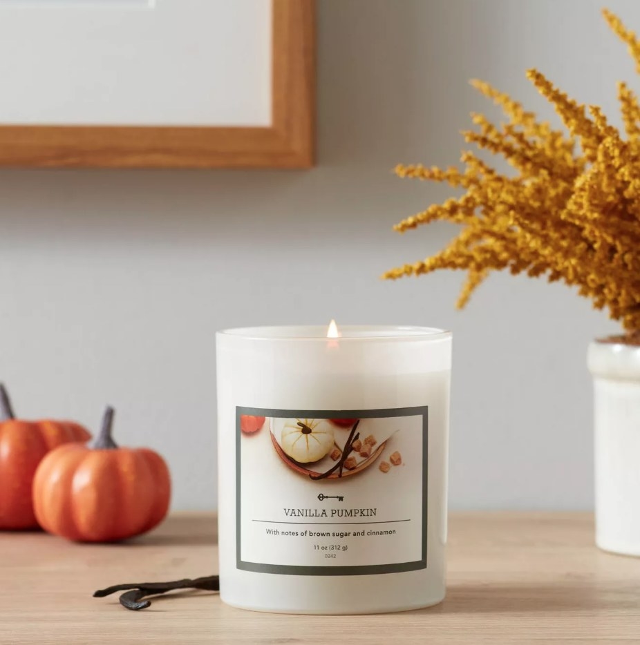 A vanilla pumpkin scented candle atop a table