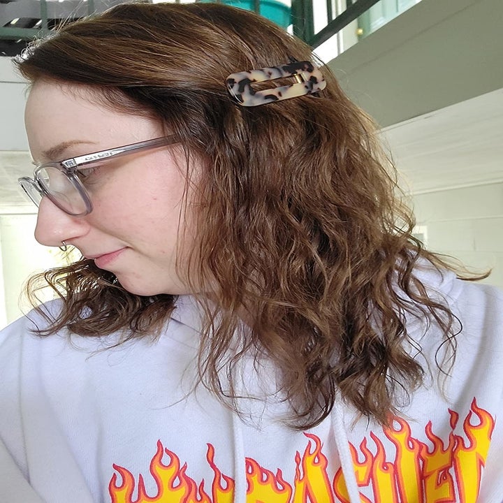 reviewer wears tortoise-shell tone rectangular clip in medium-length hair