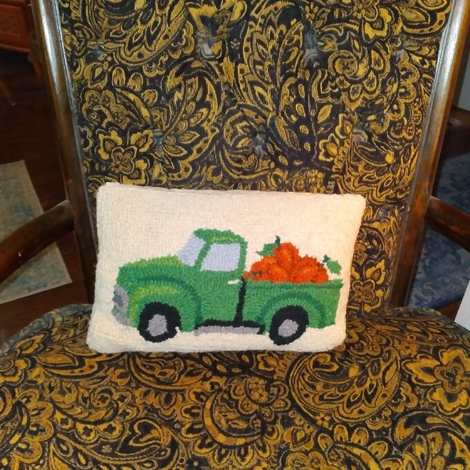 reviewer photo of white lumbar pillow with green truck and bed of pumpkins