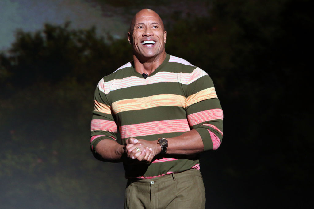 Dwayne Johnson smiling onstage at an event