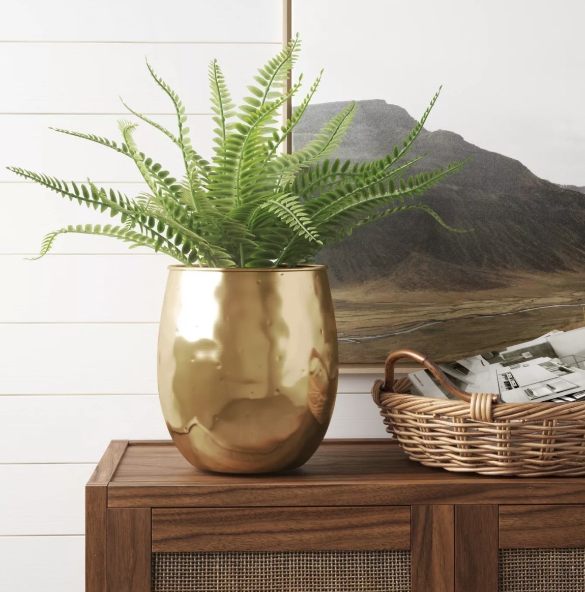 The planter is a tall vertical, shiny gold vase