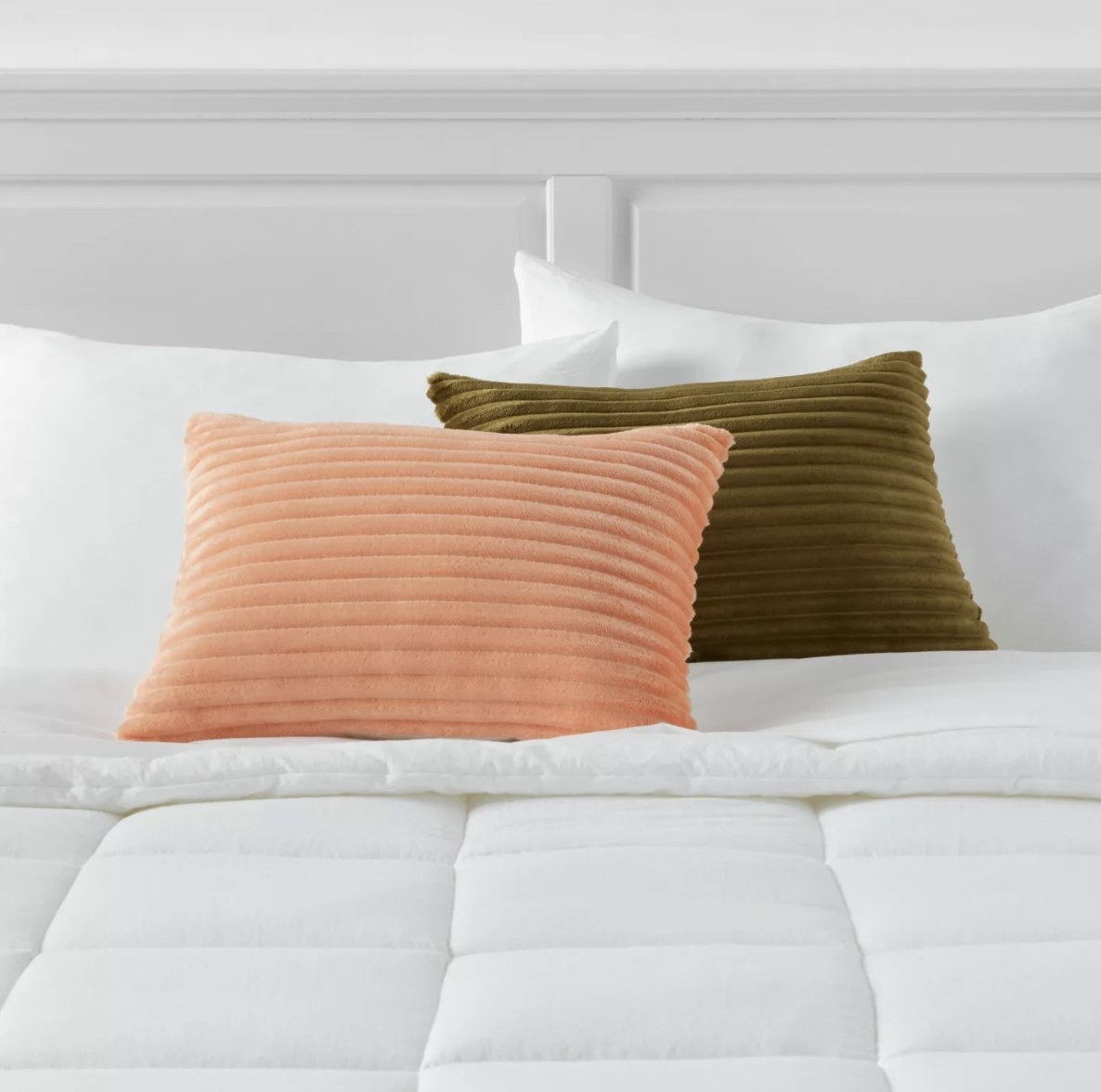 There are a set of peach and olive colored pillows with horizontal plush indents