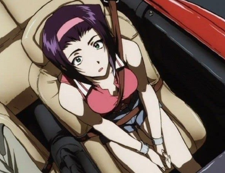 Faye looking up while sitting in a convertible