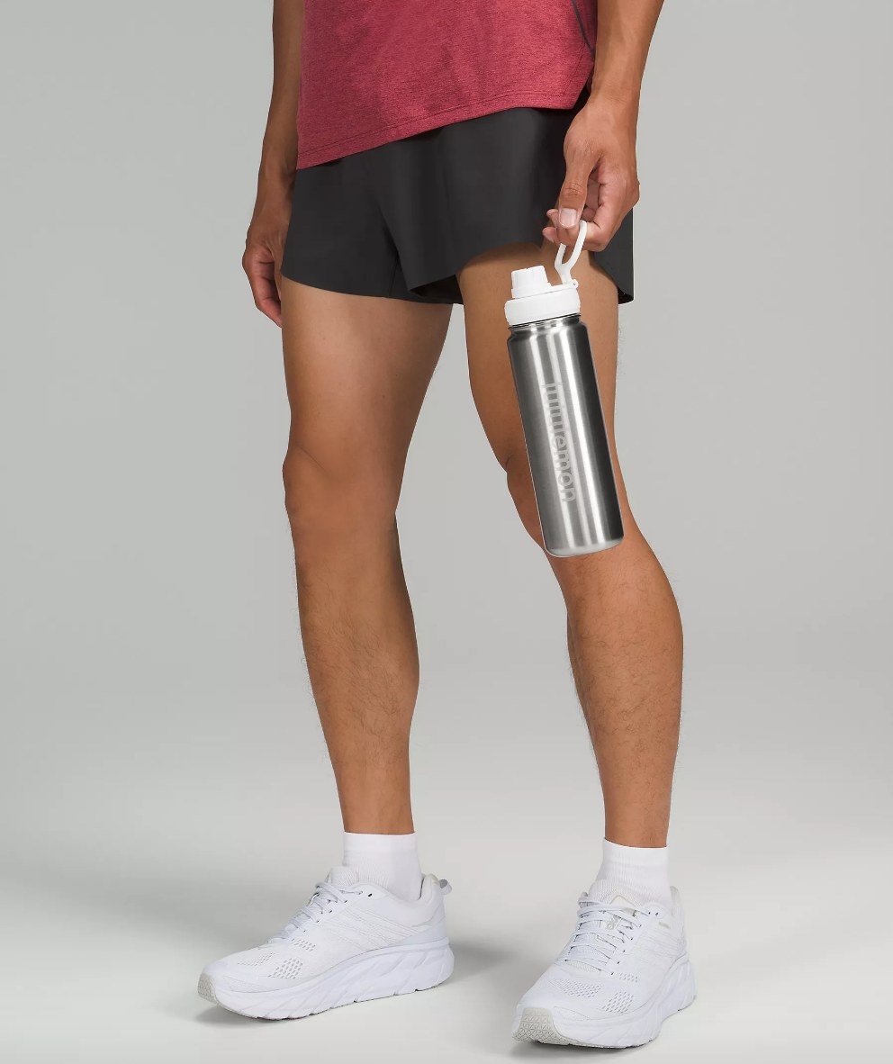 Model holding silver water bottle with white top
