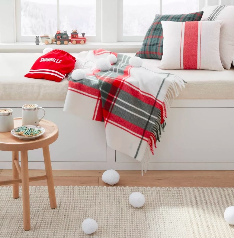 The red bag labelled snowballs on couch with the soft plush indoor snowballs spread across the living room couch