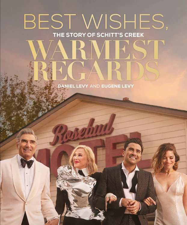 A picture of the book cover of Best Wishes, Warmest Regards feature the four main characters smiling in front of the Rosebud Motel