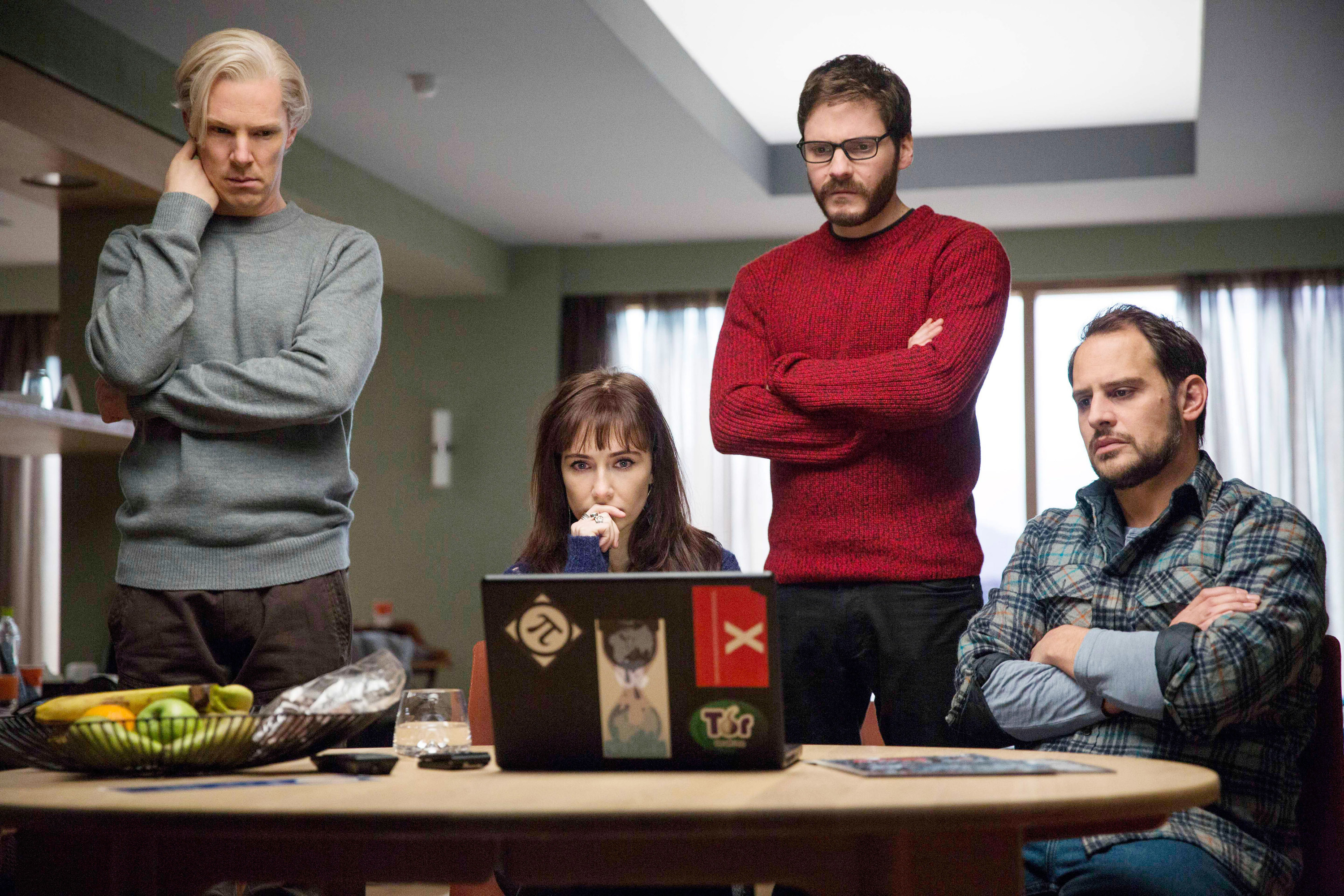 Assange and his allies look at a computer