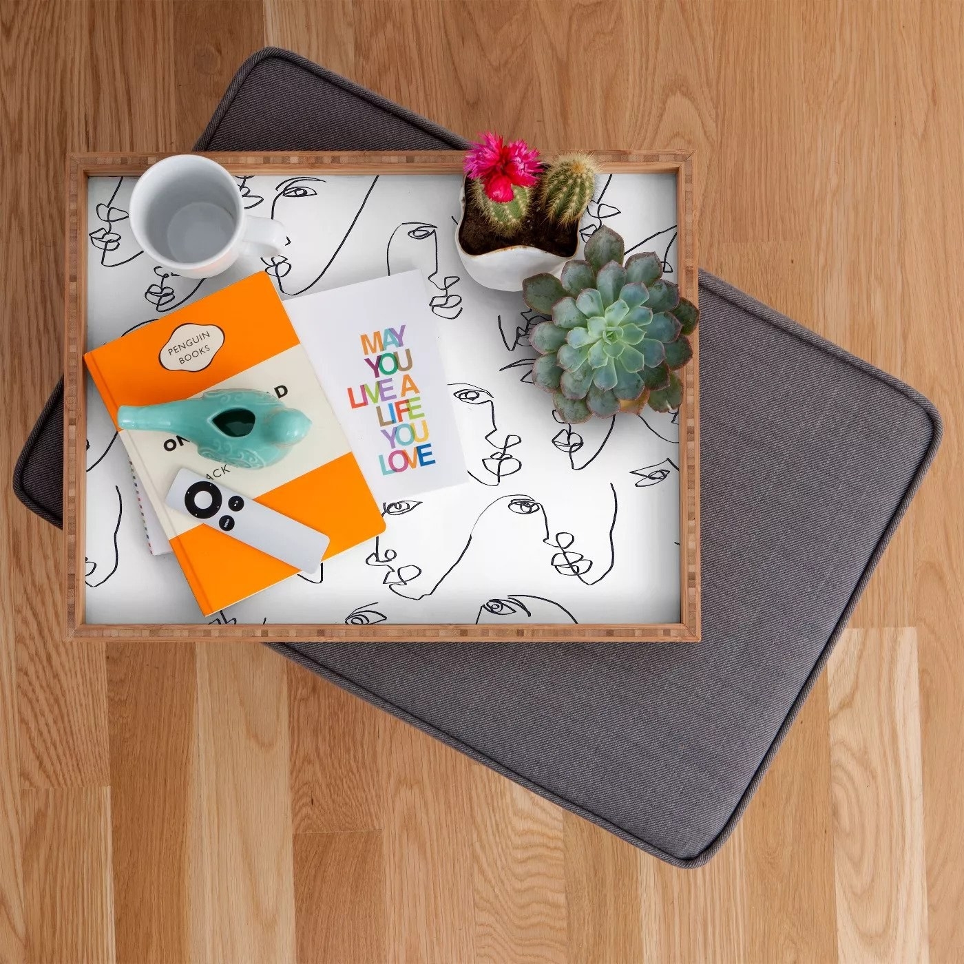 the tray with plants and other items on top of it sitting on gray pad on wood floor