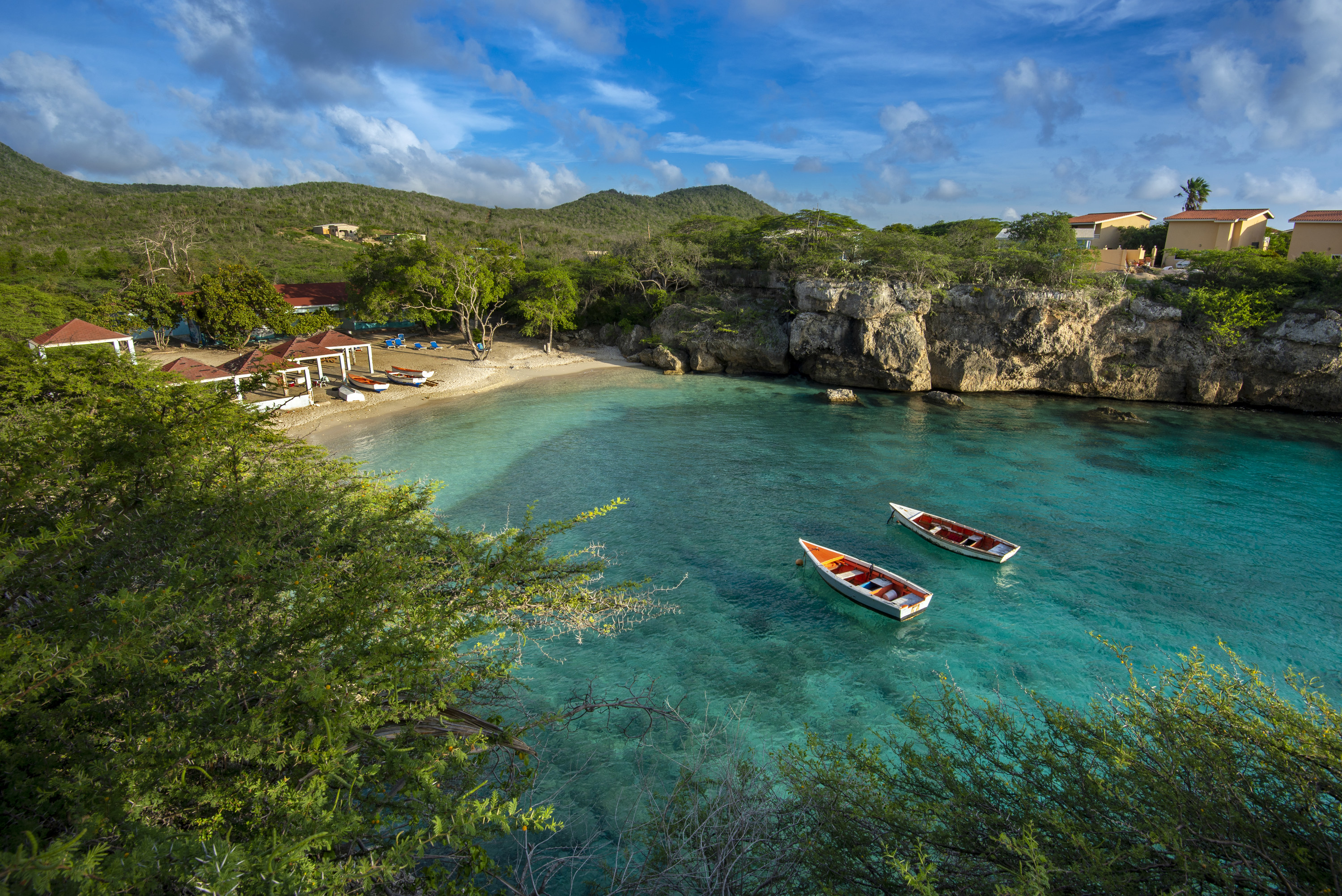 Two wooden fishing boats on the crystal clear turquoise waters at Lagoon on Curacao.