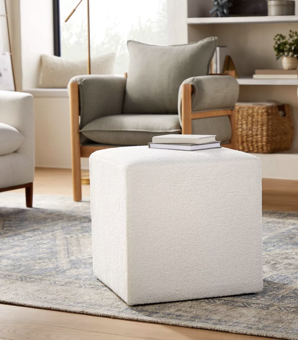 The white upholstered cube has a rounded top and fuzzy sides all around