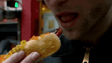 GIF man eating hot dog in slow motion