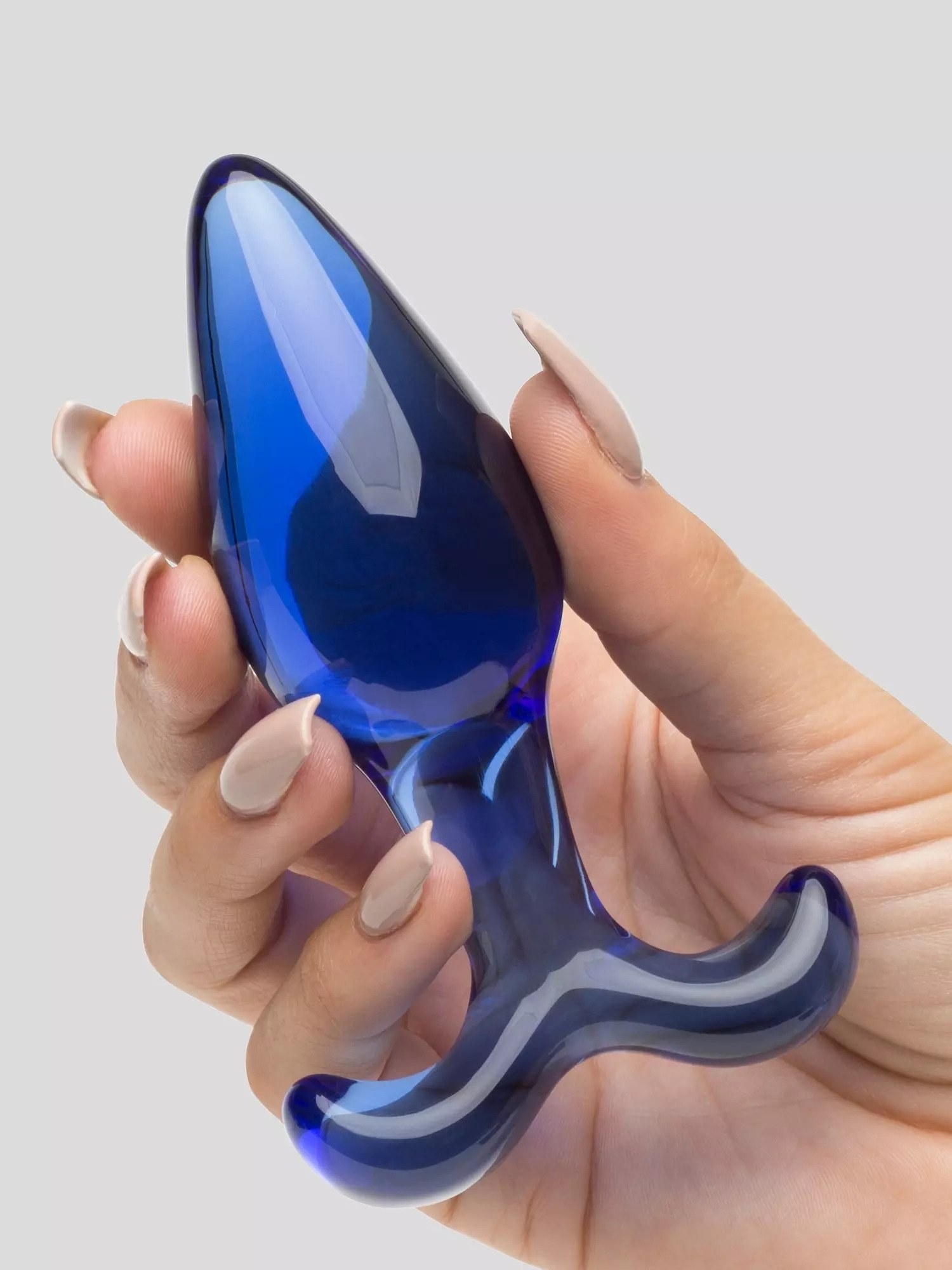 Model holding blue glass butt plug with curved flared base