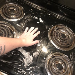 The writer cleaning the stove top