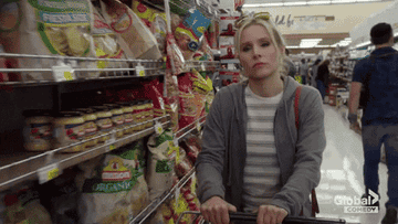 GIF woman throwing bags of chips into trolley at the store