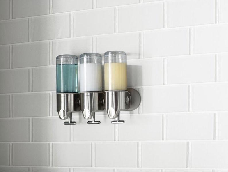 The triple dispenser mounted to a shower wall