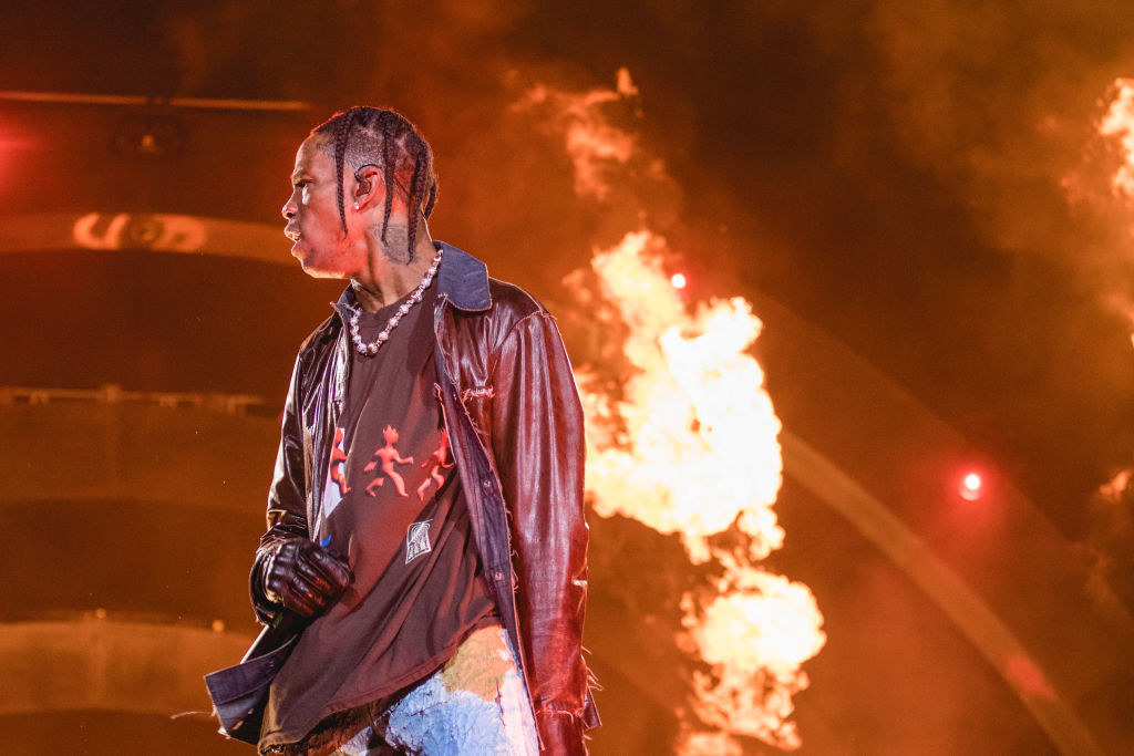 Travis Scott onstage with flame special effects behind him