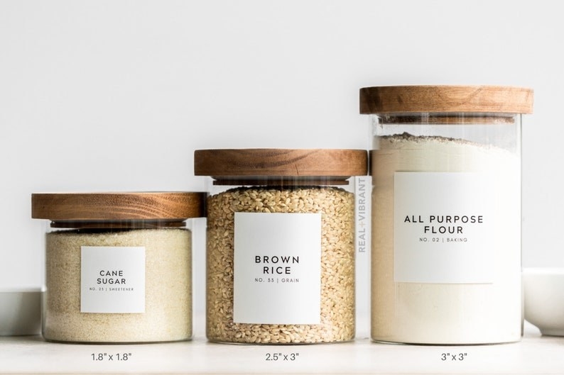 Three canisters with labels for cane sugar, brown rice, and all purpose flour