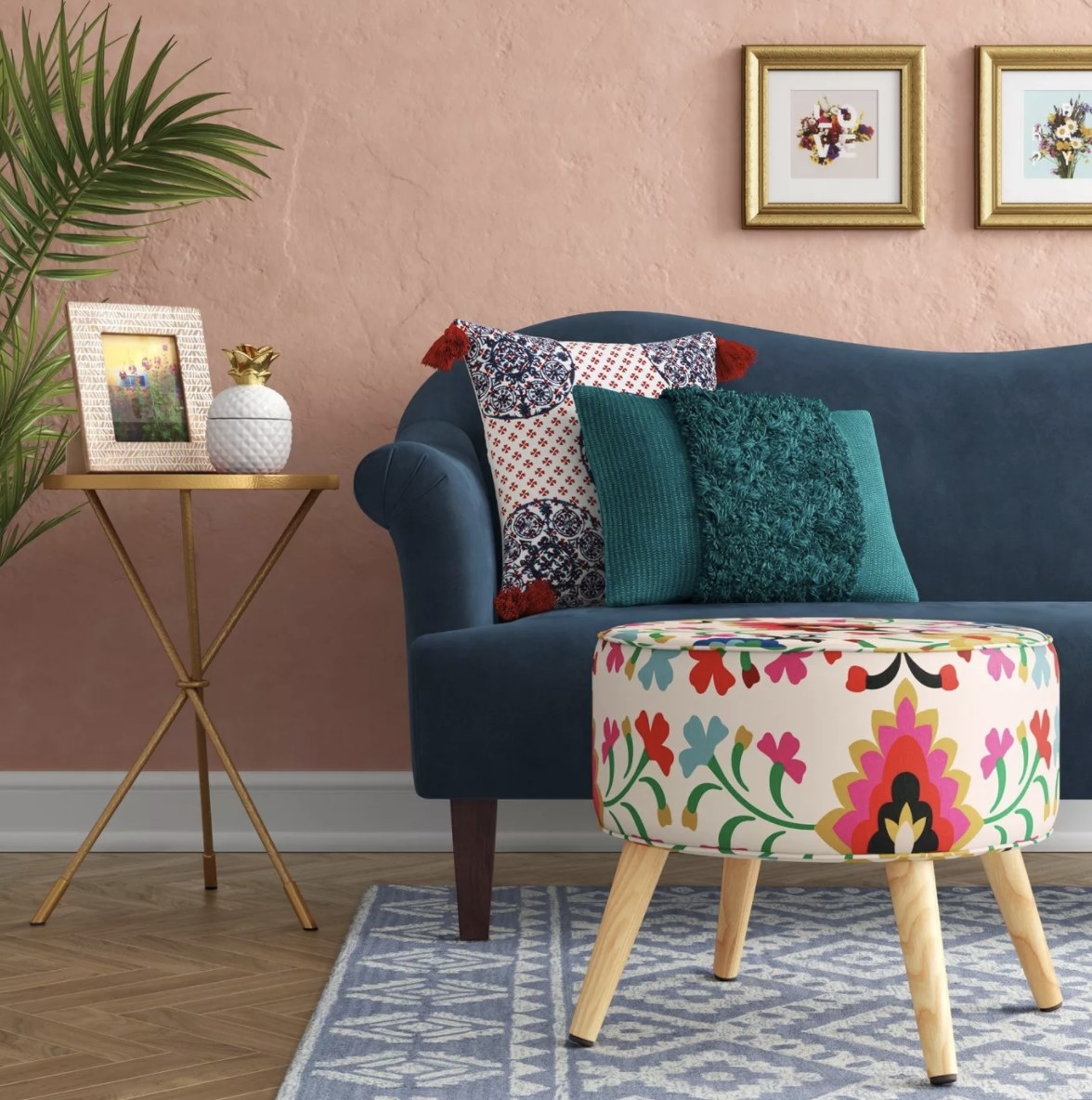 The pink, blue and yellow toned floral ottoman has four light wooden legs