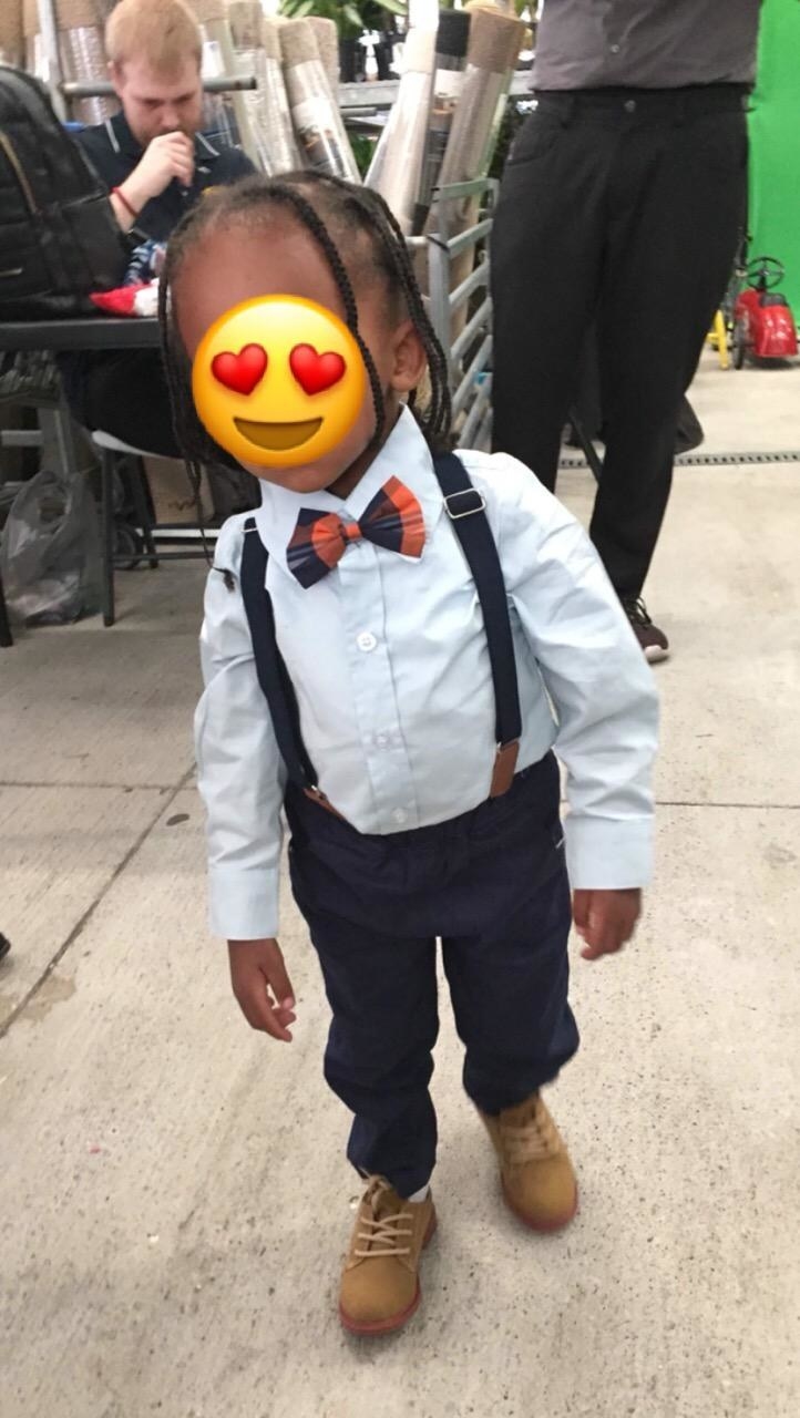 a reviewer&#x27;s child in a dress shirt, pants, bow tie, and suspenders