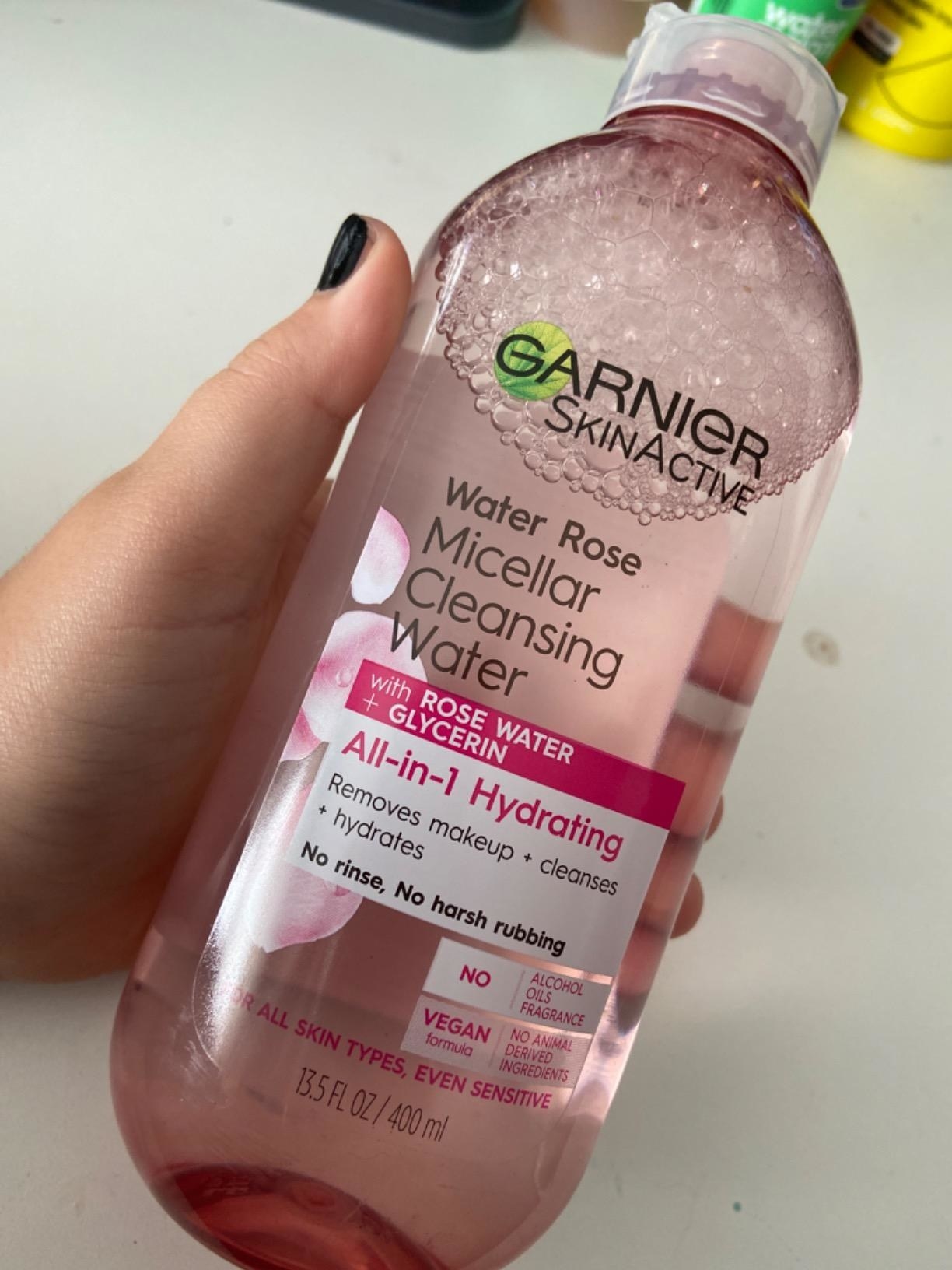 Reviewer photo of them holding the bottle of Garnier SkinActive rose micellar water