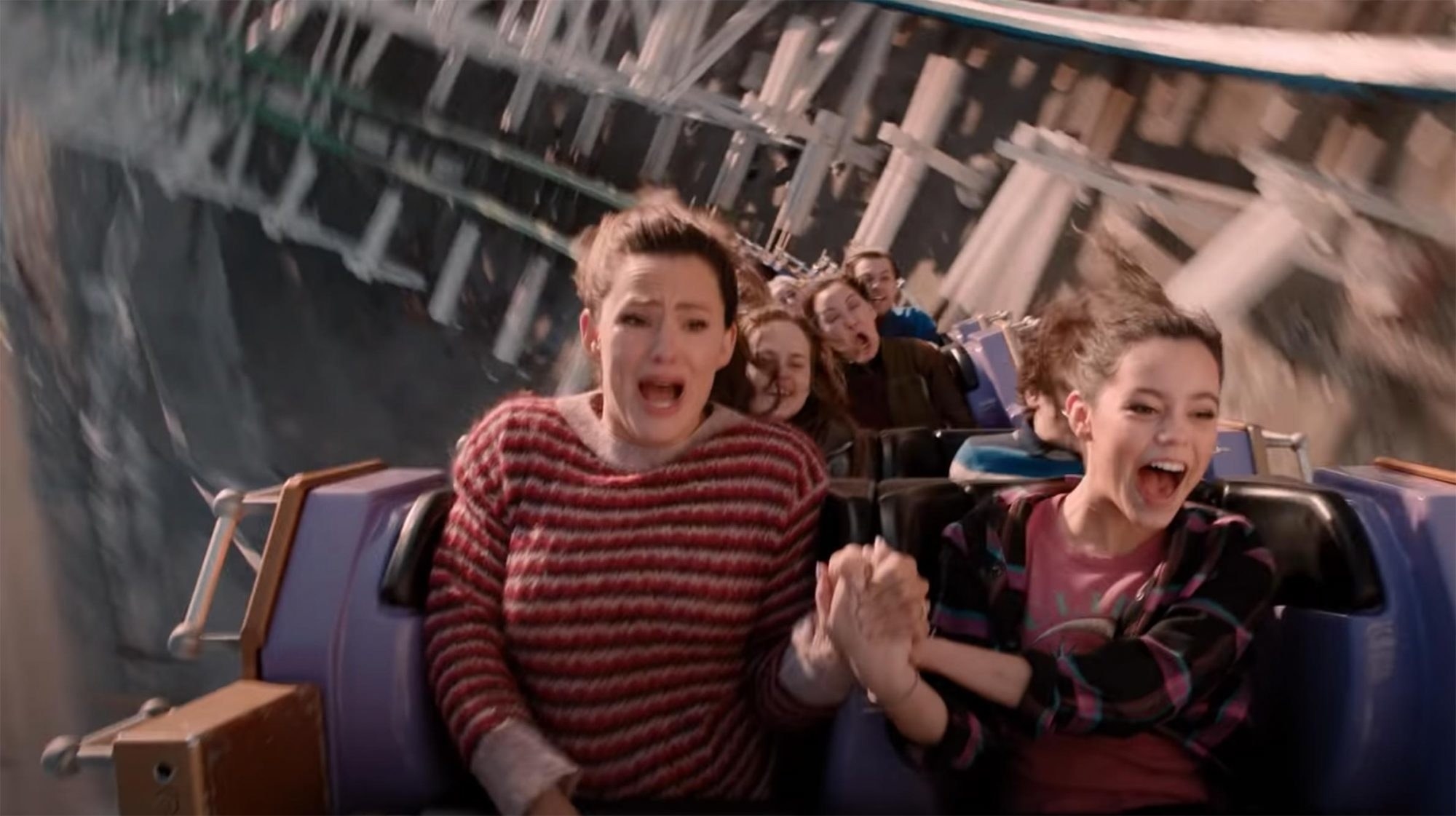 A mom and her daughter screaming while riding a roller coaster