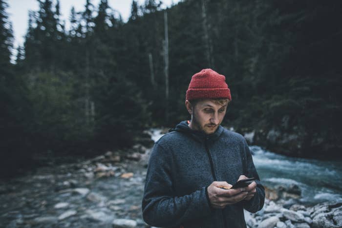 A man on his phone in a creek