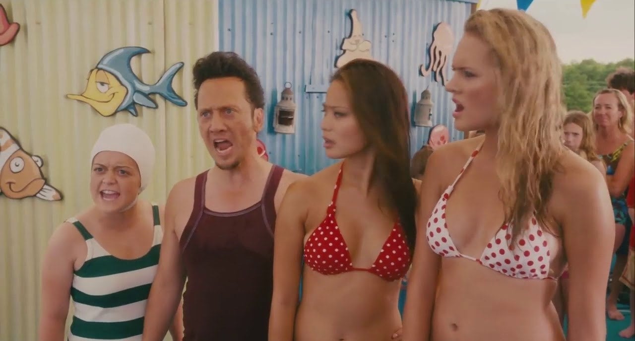 Three daughters and their dad wearing bathing suits at a water park