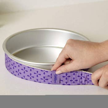 Model adjusting the strip to fit around a cake pan