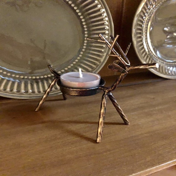 A close-up of a reviewer's reindeer candle holder