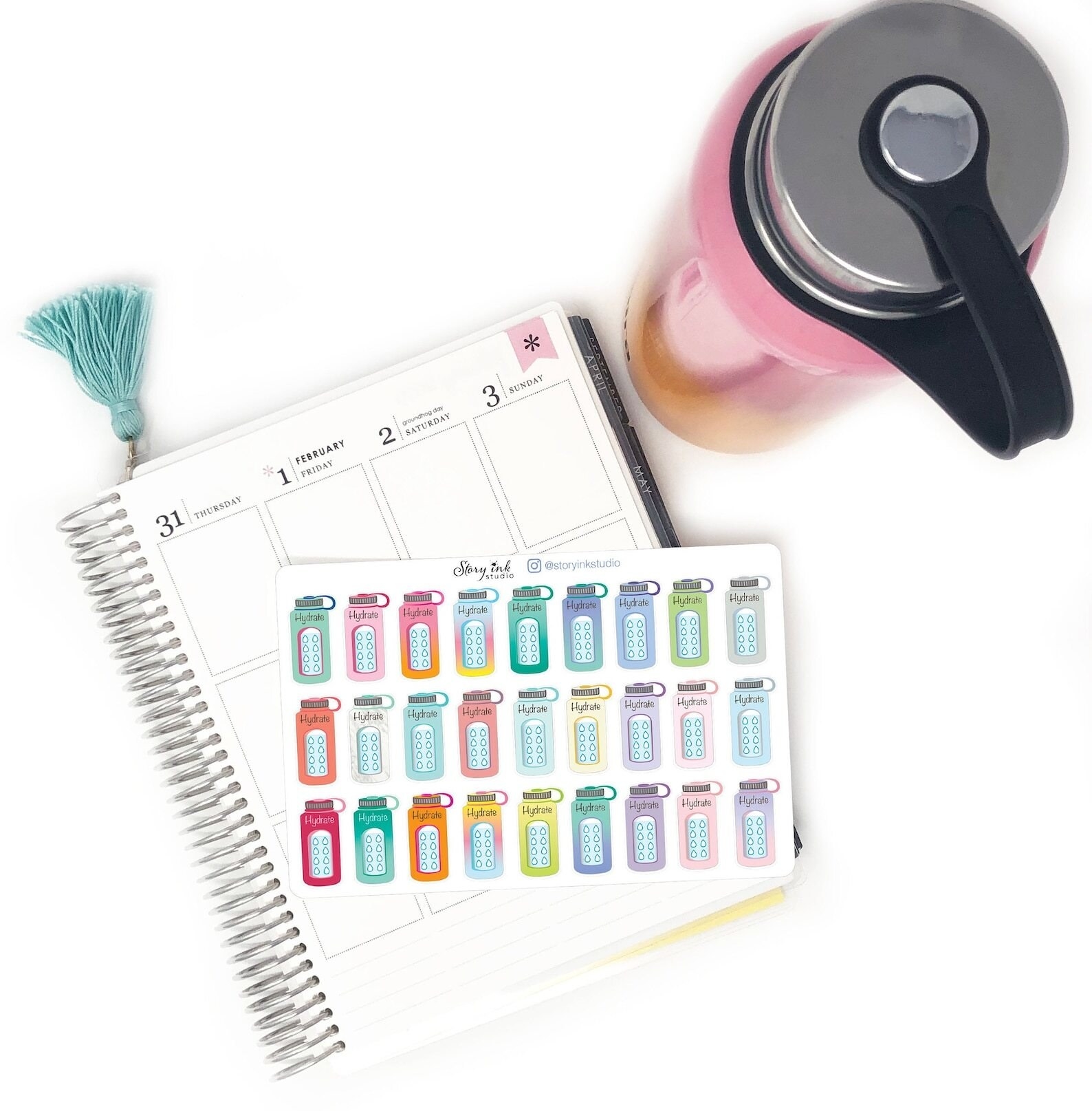 planner with a sheet of colorful water bottle stickers. each sticker has water droplets to fill in after drinking a glass of water.