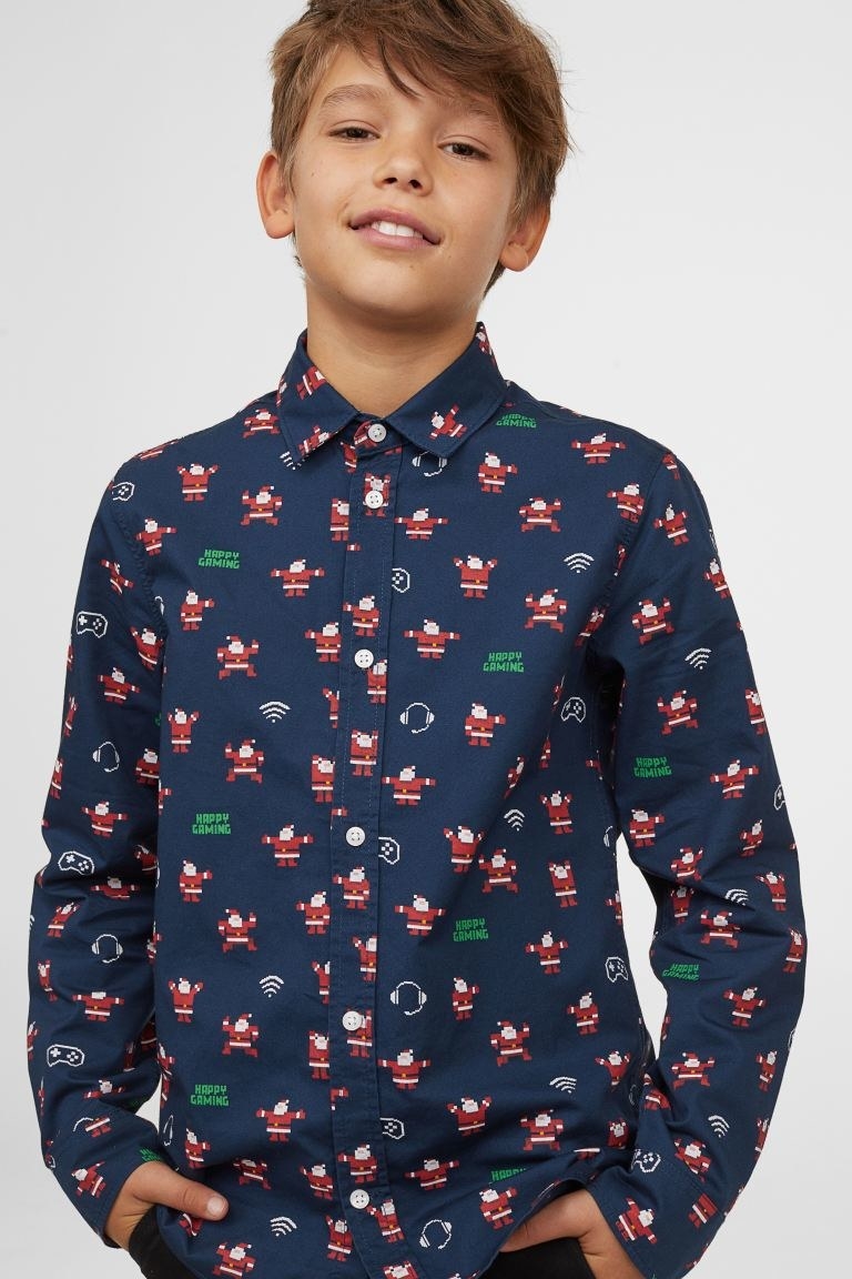 a boy in the navy blue shirt with holiday and gaming icons all over it