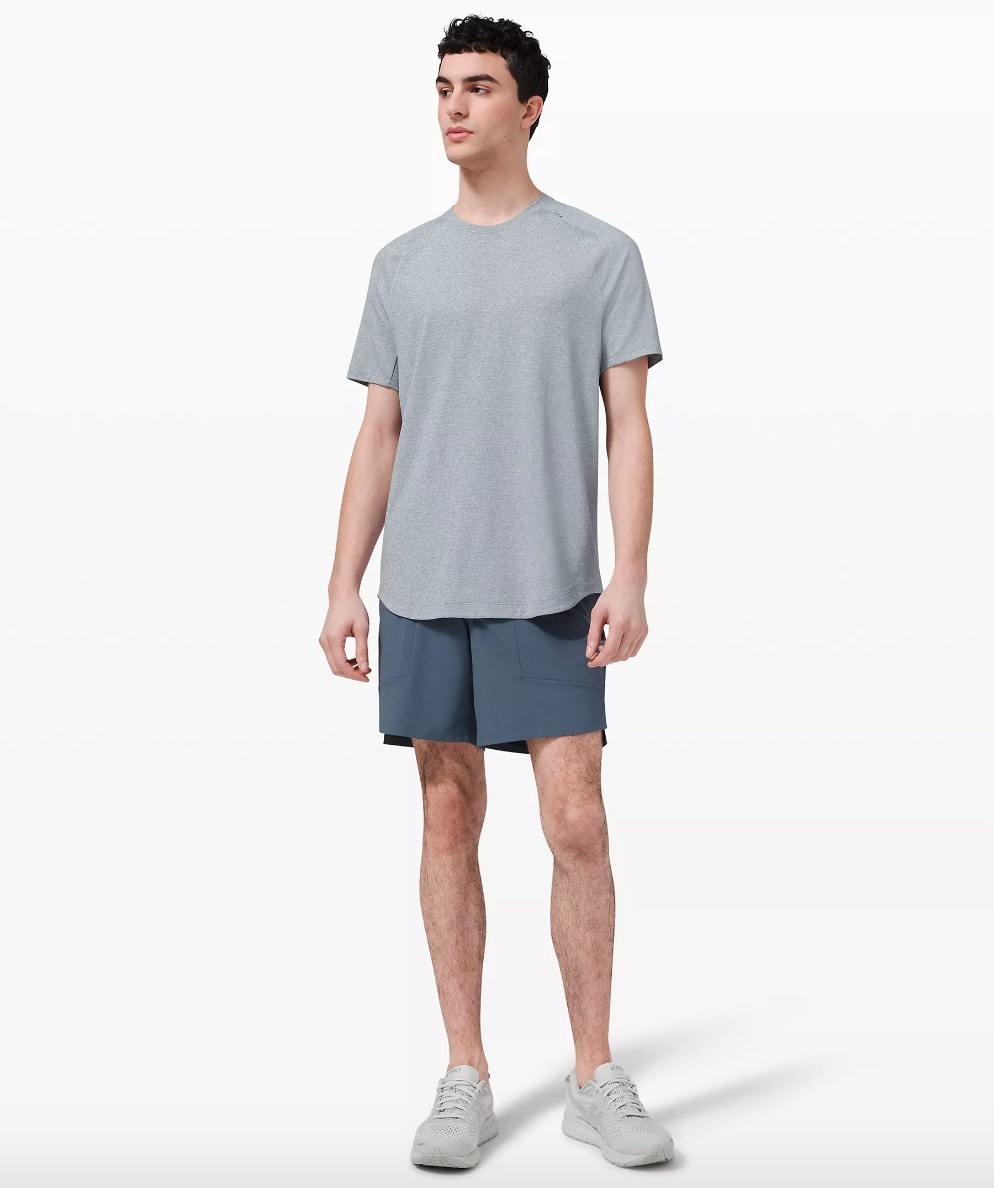 Model wearing gray training tee with blue shorts