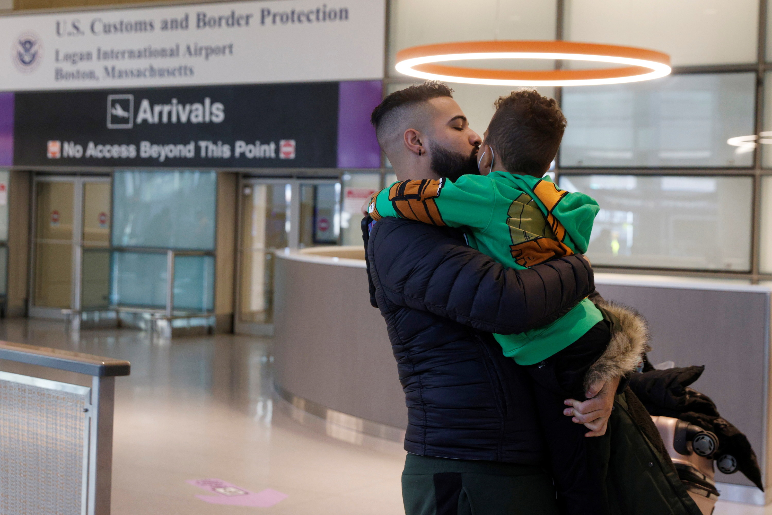 Daniel Guerrero hugs his 3-year-old son, Milan, after Milan arrived at Logan International Airport from the Dominican Republic on Nov. 8, 2021