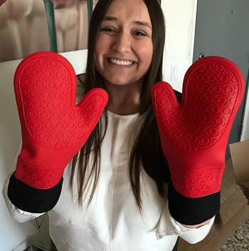 Reviewer wearing the red and black oven mitts