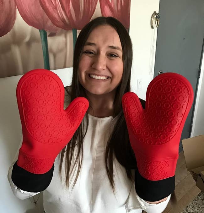 Reviewer wearing the red and black oven mitts