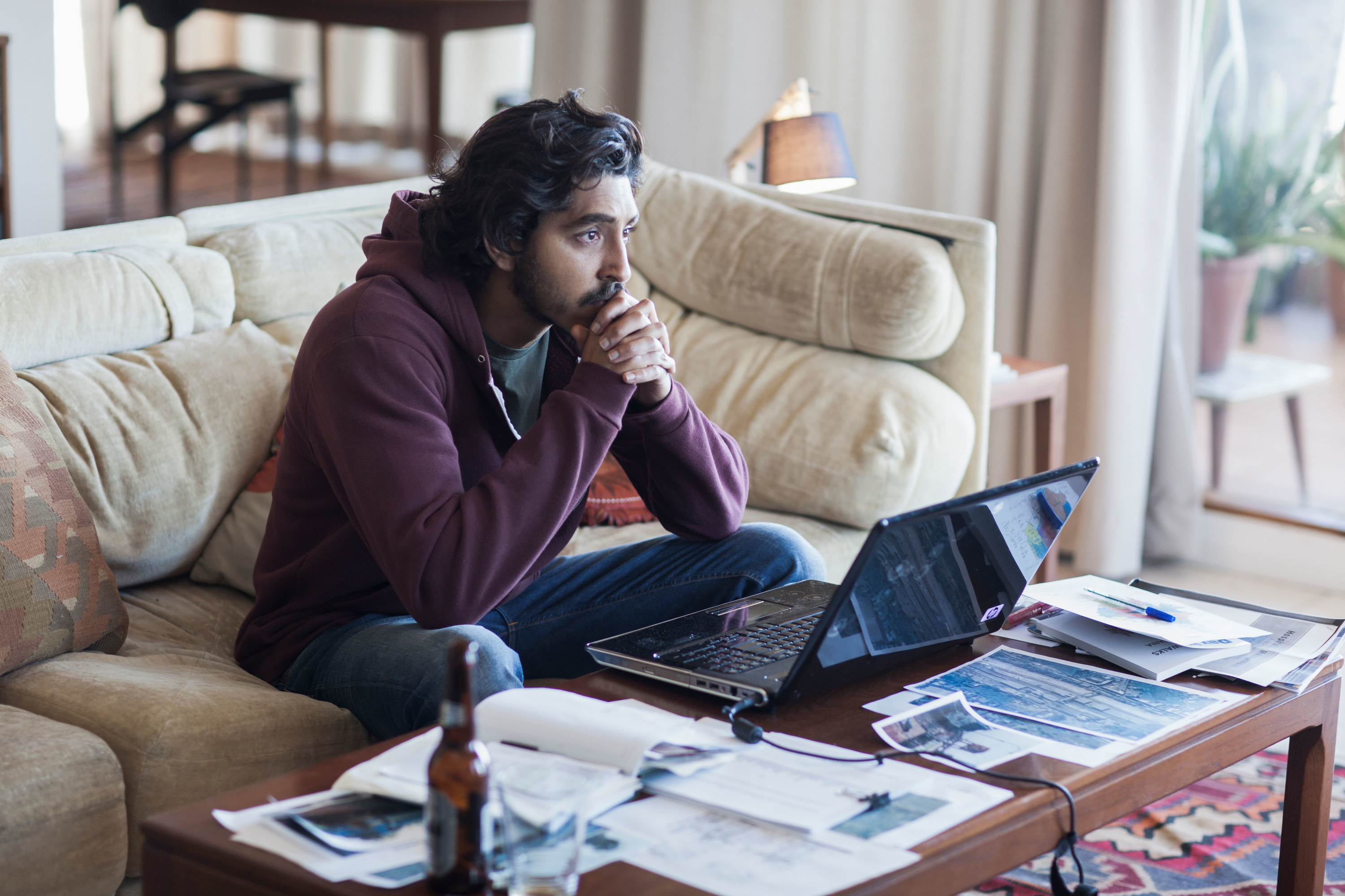 Saroo (played by Patel) doing research at his coffee table